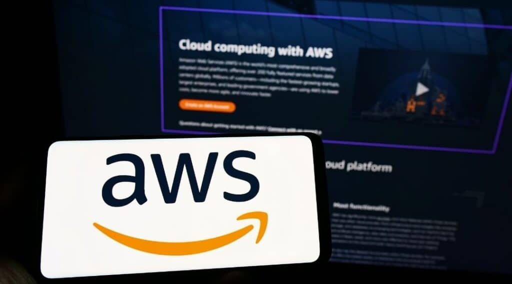 Mobiltelefon mit dem Logo des US-amerikanischen Cloud-Unternehmens Amazon Web Services Inc. (AWS) auf dem Display vor einer Webseite. Fokussierung auf das Display des Telefons.